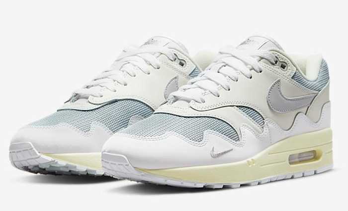 View of white and grey Nike Air Max 1 shoes.